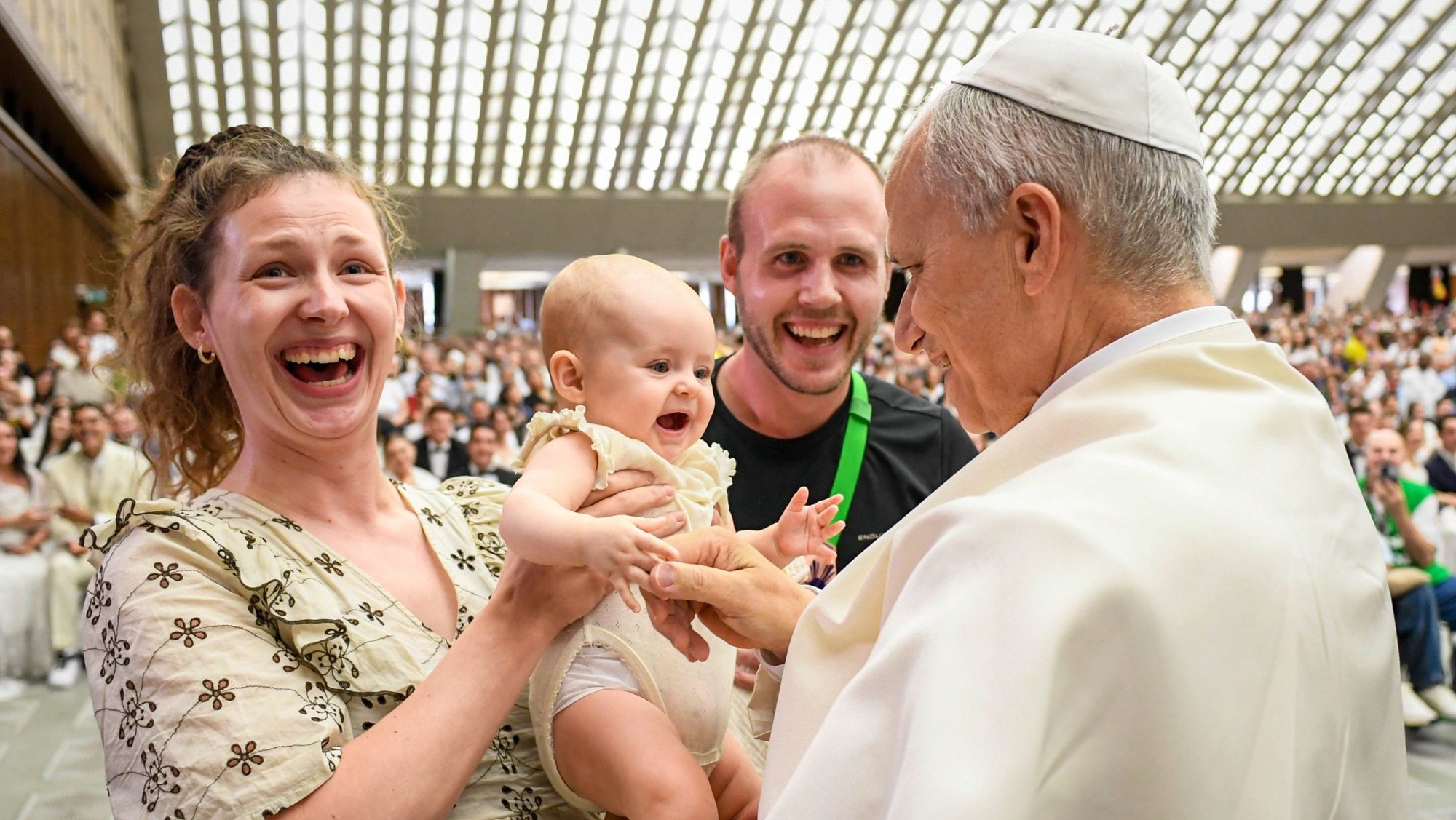 Pope Leo XIV greets a baby and family at the conclusion of his weekly general audience in the Paul VI Audience Hall at the Vatican Aug. 27, 2025. (CNS photo/Vatican Media)