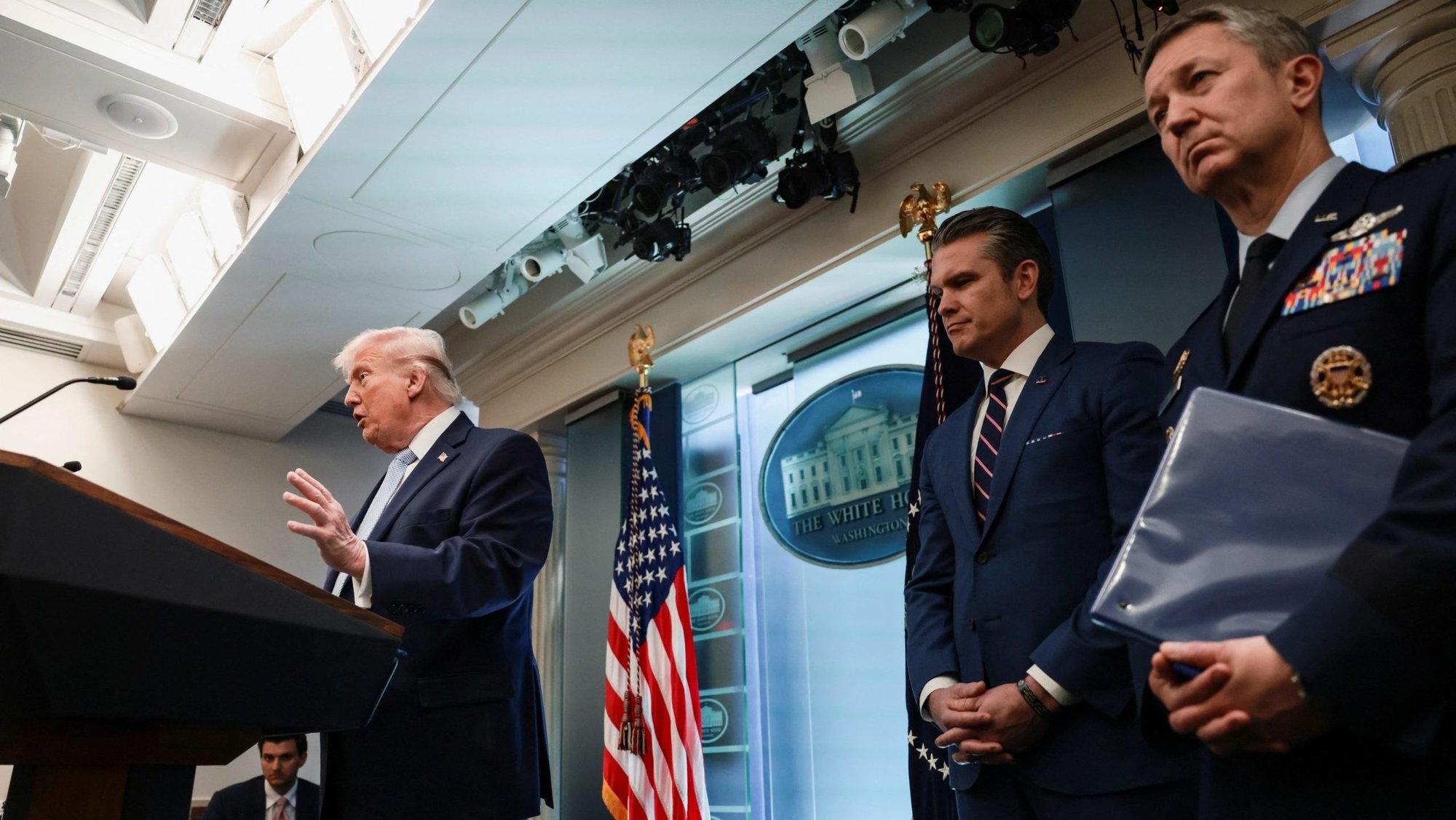 U.S. Secretary of Defense Pete Hegseth and Chairman of the Joint Chiefs of Staff Gen. Dan Caine listen while President Donald Trump answers questions from the media during a news conference in the James S. Brady Press Briefing Room at the White House in Washington April 6, 2026. Trump on April 7 sharply ramped up his threats against Iran, warning "a whole civilization will die tonight" unless the country's leadership strikes a deal that involves reopening the Strait of Hormuz. (OSV News photo/Evelyn Hockstein, Reuters)