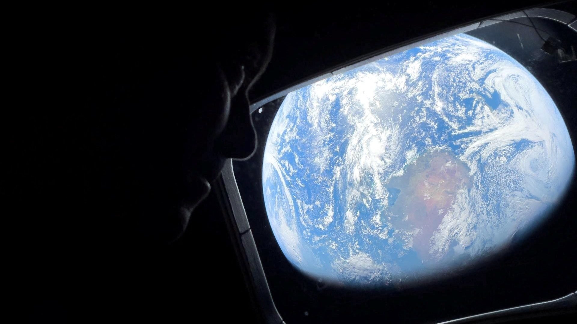 NASA astronaut and Artemis II commander Reid Wiseman peers out of one of the Orion spacecraft’s main cabin windows April 2, looking back at Earth as the crew travels toward the Moon. (OSV News/NASA Handout via Reuters)