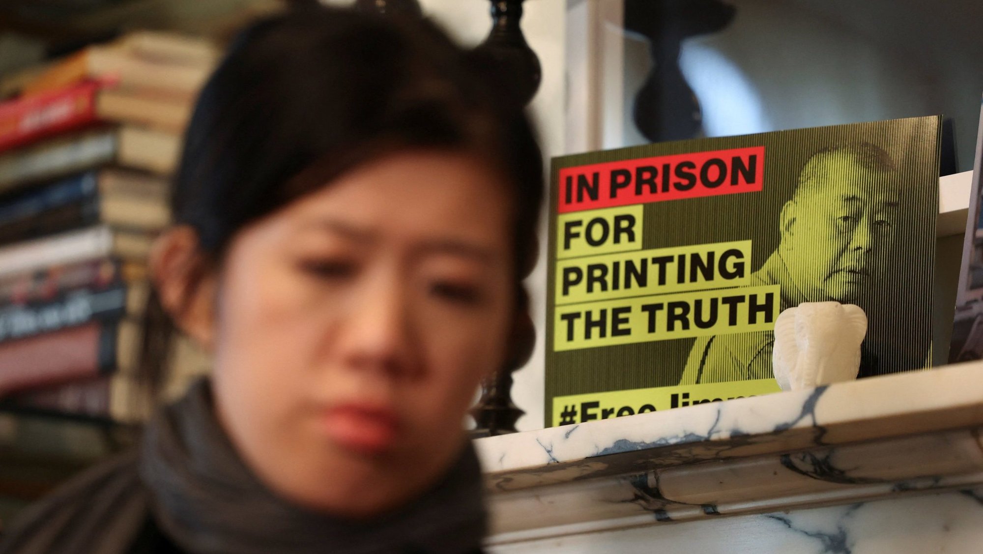 A sign calling for the release of media tycoon and Beijing critic Jimmy Lai who was found guilty in a Hong Kong court of national security charges, is displayed behind Lai's daughter, Claire Lai, as she sits for an interview in Washington Dec. 15, 2025. (OSV News photo/Kevin Mohatt, Reuters)