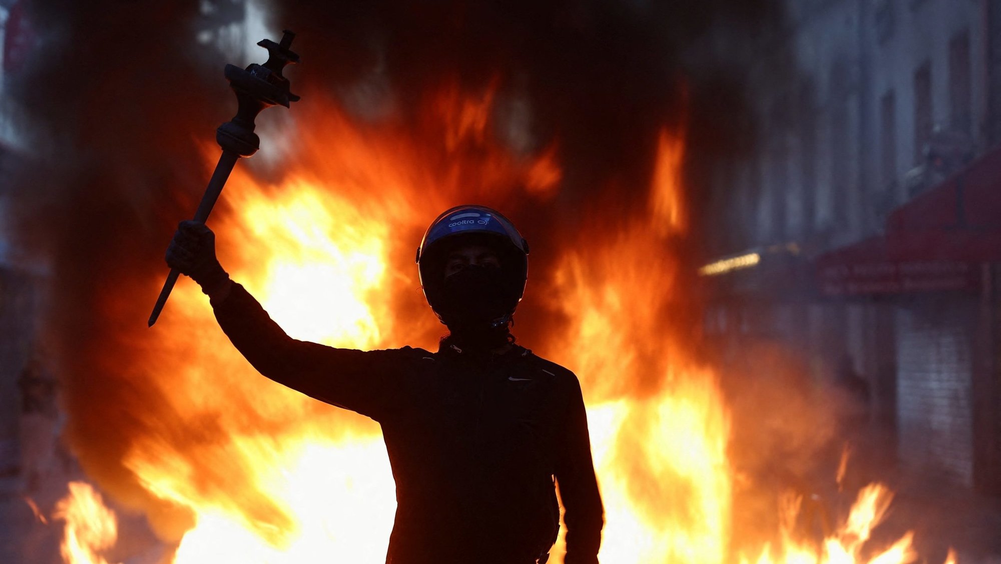 A person raises their arm during civil unrest in Paris Oct. 18, 2026, the day after a national day of demonstrations against the cost of living and rising fuel prices. (OSV News/Abdul Saboor, Reuters)