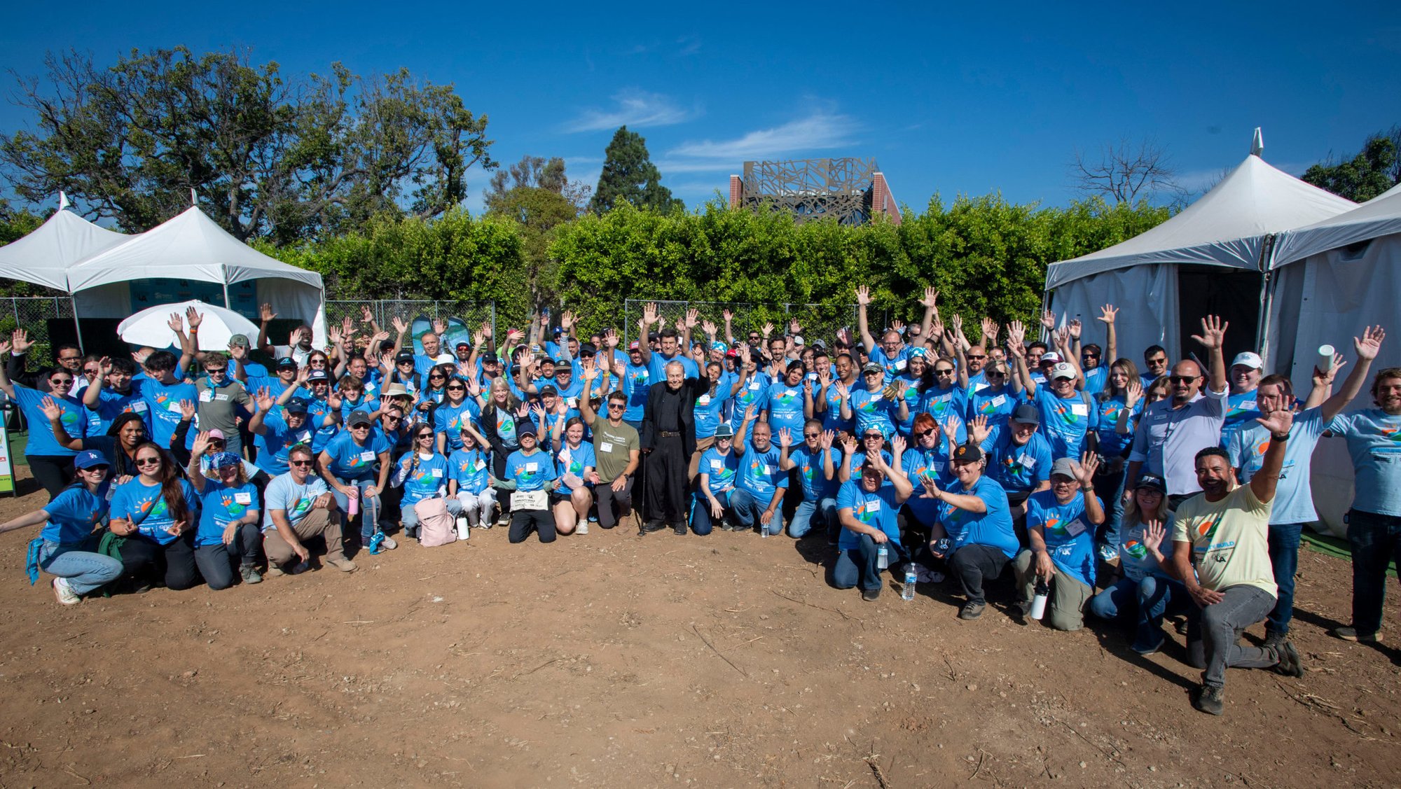 Msgr. Lloyd Torgerson, center, with volunteers from Habitat for Humanity’s local Catholic Coalition on Sept. 26 at the site of Corpus Christi Church in Pacific Palisades. Torgerson led the workers in a special blessing and prayer before they got to work. (Mike Goulding)