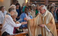 Archbishop Gomez distributes communion at the Oct. 11 Mass at St. John Fisher Church.