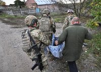 Police officers evacuate an elderly resident from the frontline rural settlement of Komyshuvakha, Ukraine, Oct. 19, 2026, amid Russia's attack on Ukraine. (OSV News photo/Reuters)