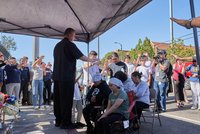 Father Mario Torres prays with grieving family.