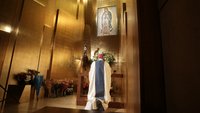 Archbishop Gomez prays before tilma fragment in LA Cathedral.