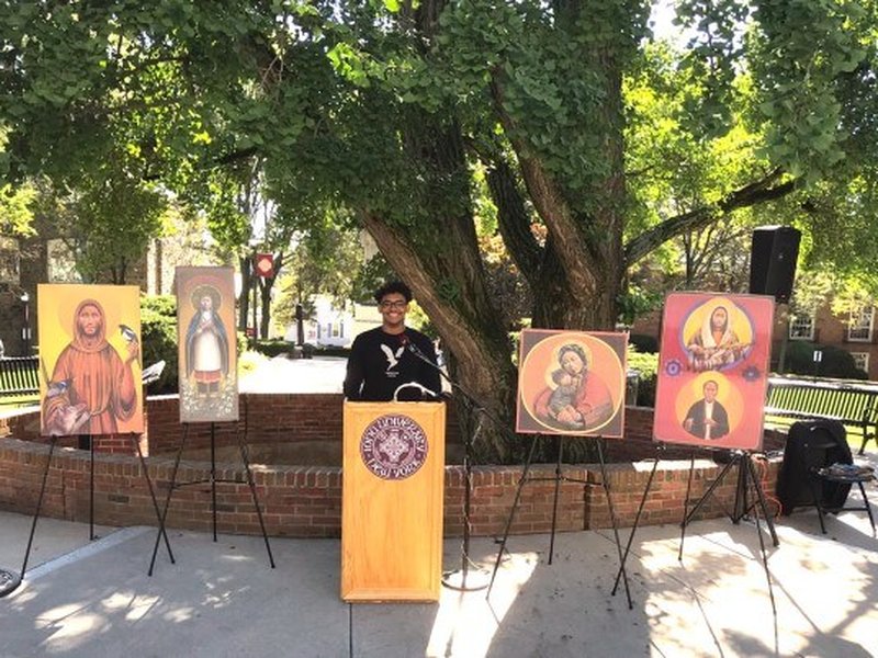 Student Fausto Rincon at podium with Icons