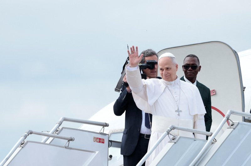 Pope Leo waves as he boards the papal plane