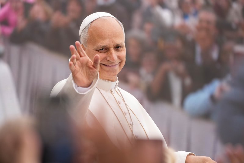 Pope Leo XIV smiles and waves from the popemobile