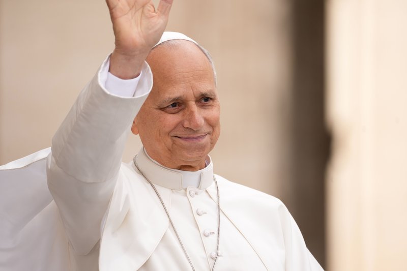 Pope Leo XIV smiles and waves from the popemobile