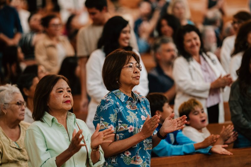 People attending the Mass have their arms outstretched in prayer.