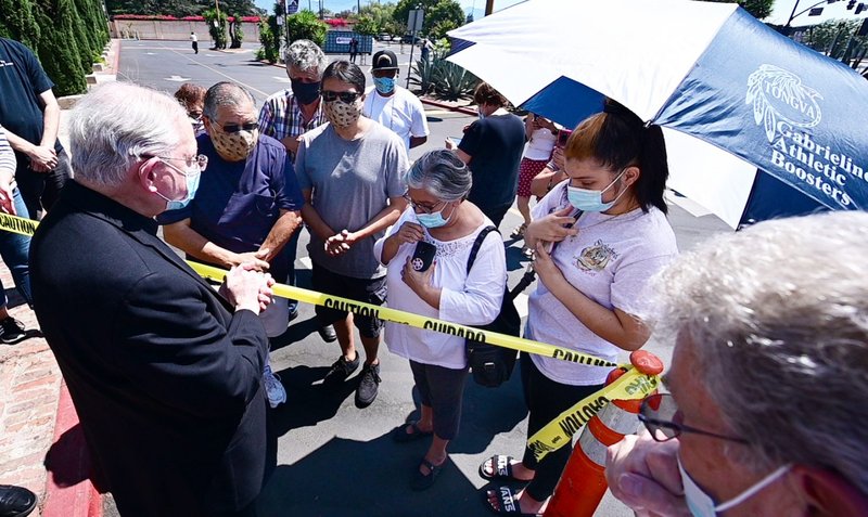 El arzobispo José H. Gómez ora con miembros de la tribu indigena De la Misión de San Gabrielino. La Misión de San Gabriel se incendió en la madrugada del 11 de julio, causando que el techo y la mayor parte del interior de la iglesia se incendiaran. El segundo de la izquierda es el jefe la tribu Anthony Morales. (John McCoy/Angelus))