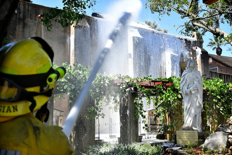 Bomberos en la escena del incendio en la Misión de San Gabriel la mañana del sábado 11 de julio. (John McCoy/Angelus)