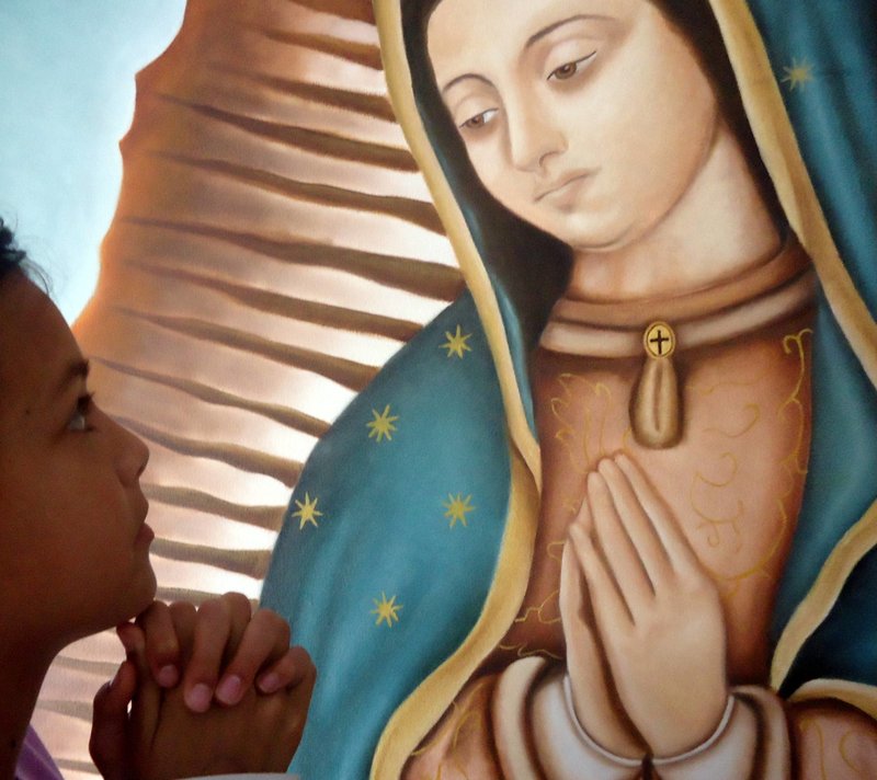 Nuestra Señora de Guadalupe y niña orando frente a ella (Cathopic)