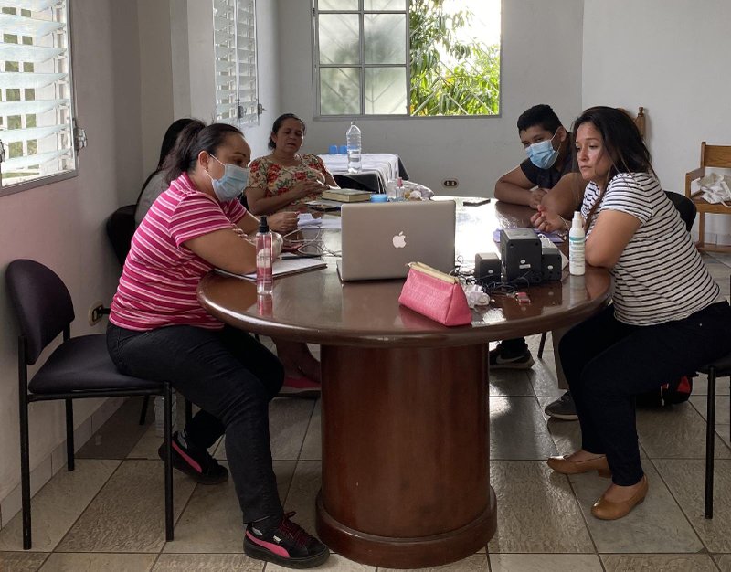 Los ministros y catequistas laicos se reúnen alrededor de una computadora portátil mientras participan en línea a través de la Escuela Diocesana en Chalatenango, El Salvador el 16 de enero de 2021. El proyecto, financiado en gran parte con la ayuda del Subcomité de la USCCB sobre la Iglesia en América Latina, proporciona instrucción de sacerdotes y expertos para ministros laicos a través de una serie de programas adaptados a las necesidades de la región rural. (Foto cnS de Rhina Guidos)