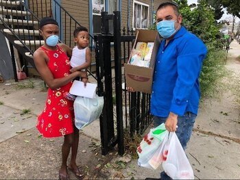 Un voluntario del programa de distribución de alimentos de la Diócesis de San Diego entrega alimentos a una familia refugiada en la ciudad durante la pandemia de coronavirus en esta foto sin fecha. (Foto del CNS/cortesía Caridades Católicas de San Diego)
