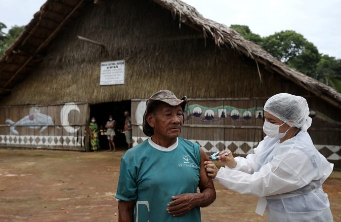 Un hombre indígena recibe la vacuna AstraZeneca/Oxford COVID-19 de un trabajador de salud municipal en la Reserva de Desarrollo Sostenible de Tupe en Manaos, Brasil, 9 de febrero de 2021. (Crédito: Bruno Kelly/Reuters a través de CNS.)