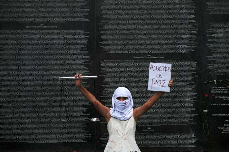 Un activista es fotografiado frente al Monumento a la Memoria y la Verdad en el Parque Cuscatlan en San Salvador, El Salvador, el 16 de enero de 2021, durante una protesta para conmemorar el 29 aniversario de la firma de los acuerdos de paz que puso fin a la guerra civil de El Salvador. Foto del CNS/José Cabezas, Reuters