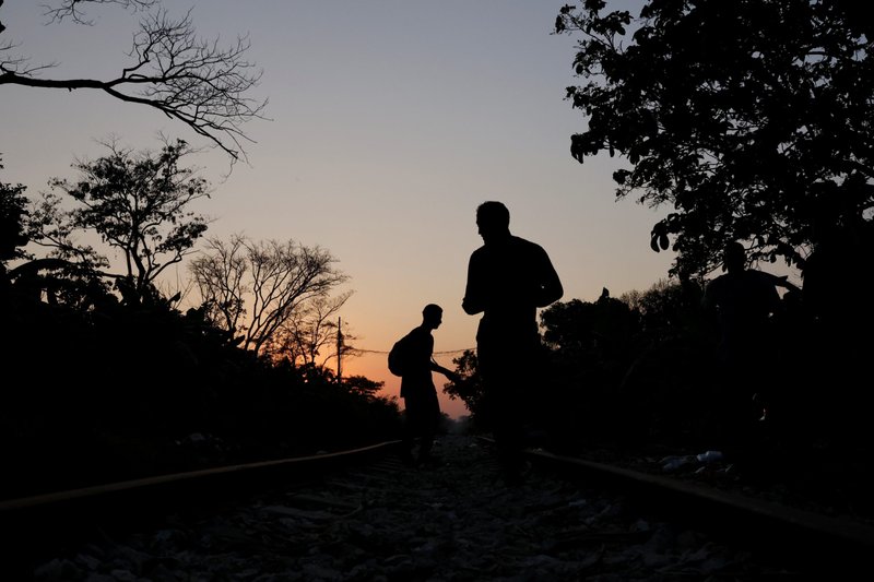 Un grupo de migrantes centroamericanos descansan a lo largo de la vía férrea en Macuspana, México, el 25 de marzo de 2021, en su camino a los Estados Unidos. (Foto CNS/Carlos Jasso, Reuters)