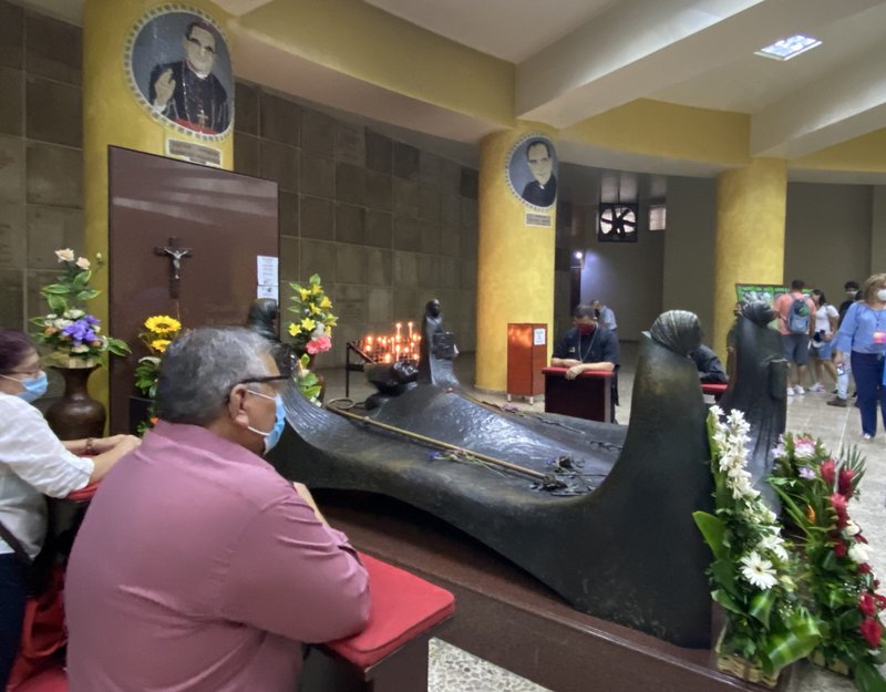 Con las restricciones de COVID-19 vigentes, católicos se reunieron en grupos más pequeños alrededor de la tumba de San Óscar Romero en la catedral de San Salvador, El Salvador, el 24 de marzo de 2021, el 41 aniversario del martirio del santo salvadoreño. (Foto CNS/Rhina Guidos)