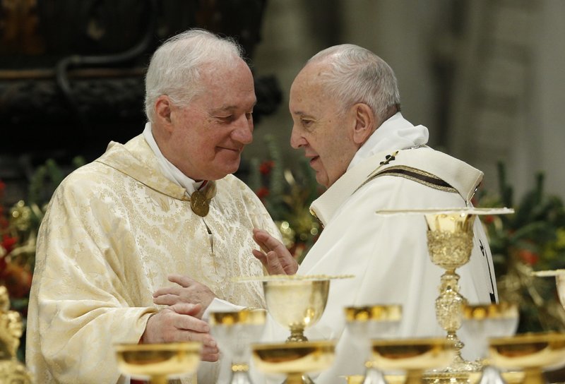 El Papa Francisco saluda al cardenal Marc Ouellet, prefecto de la Congregación para los Obispos, durante el signo de la paz en una misa en la Basílica de San Pedro en el Vaticano en esta foto de archivo del 6 de enero de 2020. El cardenal Ouellet anunció sus planes para una importante conferencia internacional en el Vaticano en 2022 sobre la teología del sacerdocio. (Foto CNS/Paul Haring)