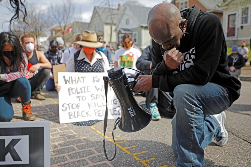Los manifestantes en St. Paul, Minn., se arrodillan para un minuto de silencio el 18 de abril de 2021, después de enterarse de otro tiroteo con la policía en otras partes de los Estados Unidos. La marcha se llevó a cabo el fin de semana antes de cerrar los argumentos en el juicio de Derek Chauvin y mientras continuaban las protestas exigiendo justicia para Daunte Wright. (Foto CNS/Nick Pfosi, Reuters)
