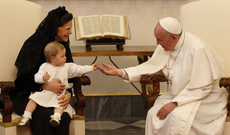 La princesa Leonore, sostenida por la reina Silvia de Suecia, le entrega un llavero papal al papa Francisco durante la audiencia privada de su abuela con el Santo Padre en el Palacio Apostólico del Vaticano en esta foto de archivo del 27 de abril de 2015. El papa ha elegido el tema "Estoy contigo todos los días" para la primera Jornada Mundial de los Abuelos y las Personas Mayores, que se celebrará el 25 de julio de 2021 (Foto de CNS / Paul Haring)