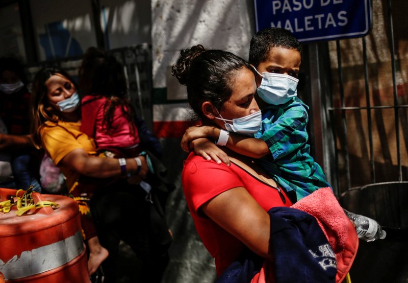 Migrantes de Centroamérica en busca de asilo, y quienes fueron transportados en avión desde Brownsville, Texas a El Paso y luego deportados, caminan frente a la oficina del Instituto Nacional de Migración en el Puente Internacional Paso del Norte en Ciudad Juárez, México, el 23 de marzo de 2021. (Foto de CNS/José Luis González, Reuters)