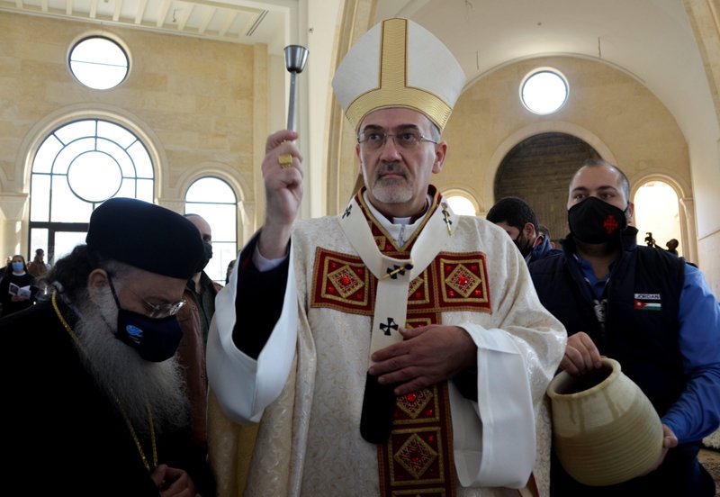 Monseñor Pierbattista Pizzaballa, patriarca latino de Jerusalén, rocía agua bendita mientras celebra la misa en la Iglesia inacabada del Bautismo de Cristo en el lugar del bautismo de Jesús en Betania Más Allá del Jordán cerca de Ammán el 9 de enero de 2021. (Foto CNS/Muath Freij, Reuters)