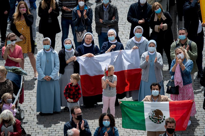 La gente sostiene las banderas nacionales de Polonia y México en la Plaza de San Pedro mientras asisten a la "Regina Coeli", dirigida por el Papa Francisco desde la ventana de su estudio con vistas a la Plaza de San Pedro en el Vaticano el 2 de mayo de 2021. (Foto CNS/Medios Vaticanos)