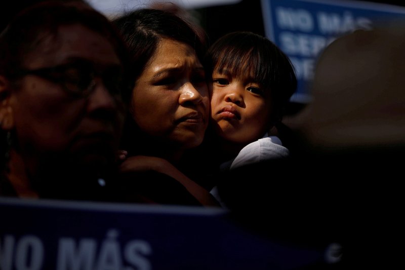 Un niño abraza a una mujer en Los Ángeles mientras durante una protesta contra una orden ejecutiva del expresidente Donald Trump que separó a niños que cruzaron la frontera sur de familias el 7 de junio de 2018. (Foto CNS/Patrick T. Fallon, Reuters)