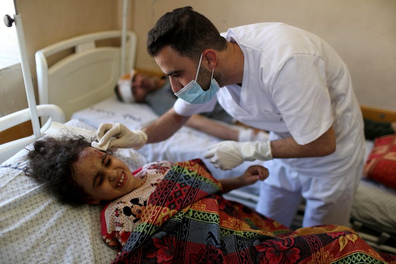 La palestina Suzy Eshkuntana, de 6 años, es tratada por un médico en un hospital después de ser sacada de los escombros de un edificio durante los ataques aéreos israelíes en la ciudad de Gaza el 16 de mayo de 2021. (Foto CNS/Mohammed Salem, Reuters)
