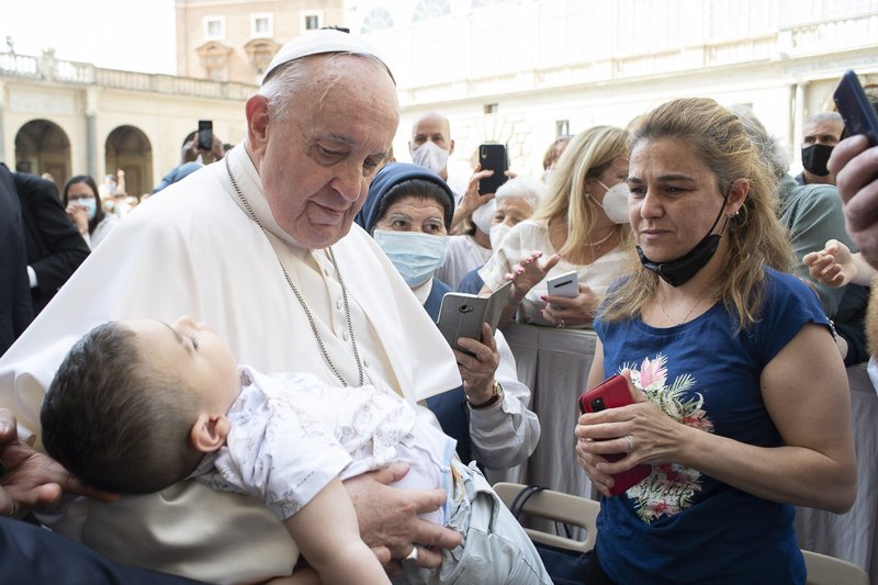 El papa Francisco tiene a un niño en sus brazos durante su audiencia general en el Patio de San Dámaso del Palacio Apostólico en el Vaticano el 16 de junio de 2021. (Foto CNS/Vatican Media)
