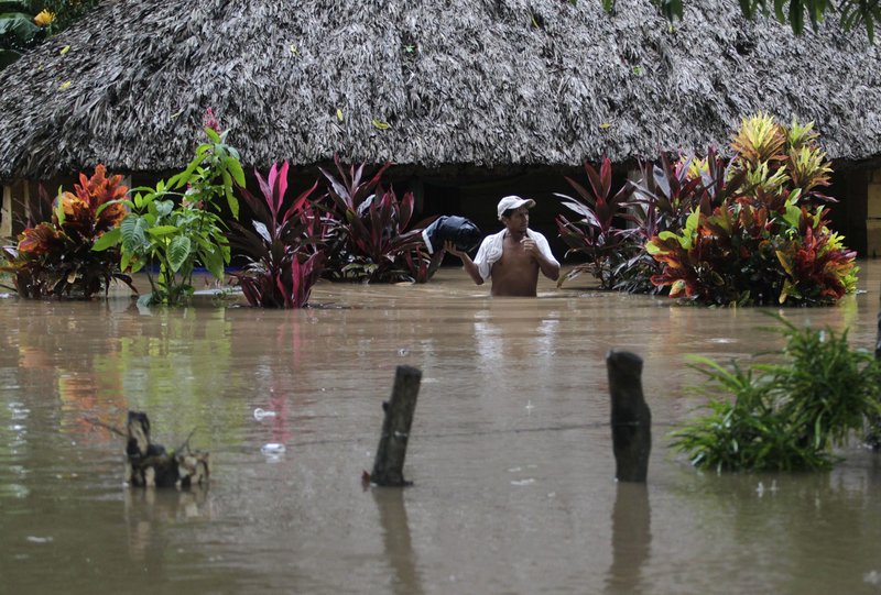 Un hombre cerca de una casa en Santa Rosa, Guatemala, atraviesa el agua tras una inundación el 13 de octubre de 2011. El daño extenso de tormentas tropicales consecutivas a fines de 2020 en medio de la pandemia ha empeorado la situación ya difícil en Guatemala, lo que llevó a los defensores de la inmigración el 14 de julio de 2021 a pedir estatus migratorio especial en los EE. UU. para ciudadanos guatemaltecos. (Foto CNS/Jorge Dan Lopez, Reuters)
