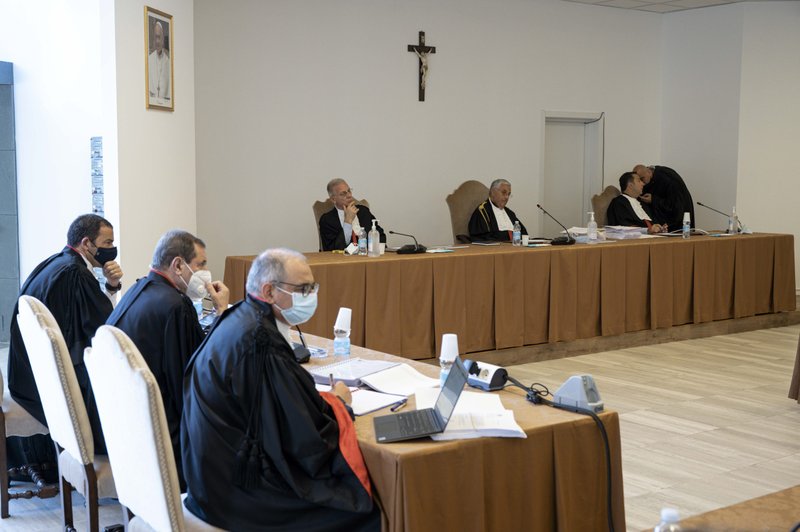 Los jueces del tribunal penal del Estado de la Ciudad del Vaticano -Venerando Marano, Giuseppe Pignatone y Carlo Bonzano- se sientan bajo un crucifijo en una sala improvisada del Vaticano el 27 de julio de 2021, mientras comienza el juicio de 10 acusados en un caso de malversación financiera. (Foto CNS /Vatican Media)