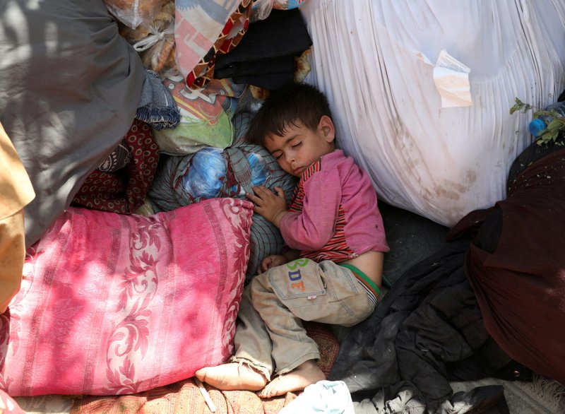 Un niño desplazado de las provincias del norte de Afganistán, que huyó con su familia debido a los combates entre los talibanes y las fuerzas de seguridad afganas, duerme en un parque público de Kabul el 10 de agosto de 2021. (Foto CNS/Reuters)