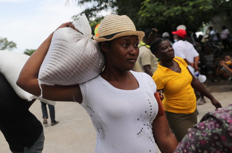 Una residente de Camp-Perrin recibe alimentos del Programa Mundial de Alimentos cerca de Les Cayes, Haití, el 19 de agosto de 2021, tras que un terremoto de magnitud 7.2 sacudiera el área cinco días antes. (Foto CNS/Henry Romero, Reuters)
