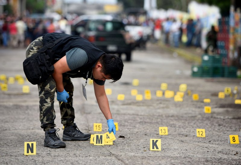 Un técnico forense busca casquillos de bala en el suelo en la escena del crimen tras un tiroteo en Tuzamapan en el estado mexicano de Veracruz el 16 de mayo de 2019. Veracruz ha sido un cementerio para periodistas durante los últimos 12 años, producto del crimen organizado y la corrupción. Los delitos cometidos contra los medios de comunicación casi siempre quedan impunes. (Foto CNS/Yahir Ceballos, Reuters)