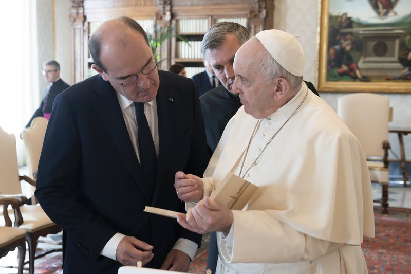 El papa Francisco regala al primer ministro francés Jean Castex un pequeño mosaico durante una audiencia privada en la biblioteca del Palacio Apostólico en el Vaticano el 18 de octubre de 2021. (CNS photo/Vatican Media)