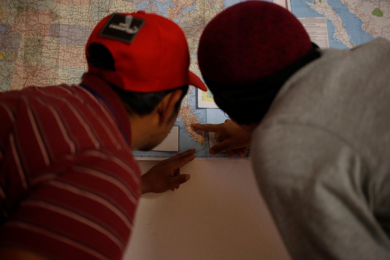 Dos migrantes a los que se les da refugio en un monasterio en Tucson, Arizona, estudian un mapa de Estados Unidos el 21 de febrero de 2019. (Foto CNS/Nicole Neri, Reuters)