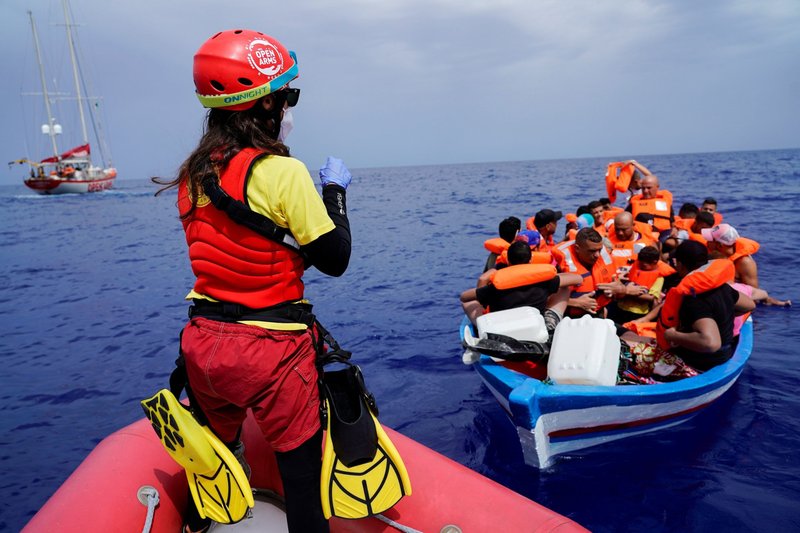 Un miembro de la tripulación de la ONG Proactiva Open Arms, del barco de rescate Astral, da instrucciones a los migrantes en un bote de madera cerca de la isla de Lampedusa, Italia, el 1 de septiembre de 2021. Los migrantes son una bendición y un regalo para la sociedad y la iglesia, pero se les debe ayudar a integrarse a las comunidades, dijo el papa Francisco en una charla el 11 de noviembre. (Foto: CNS/Juan Medina, Reuters)