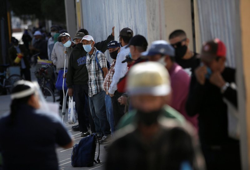 Un grupo de personas hacen fila para comer afuera de un comedor comunitario en Ciudad Juárez, México, el 15 de octubre de 2020, durante la pandemia de COVID-19. Las economías latinoamericanas se contrajeron un 7% en 2020, la peor de todas las regiones a nivel mundial, según el Fondo Monetario Internacional. (Foto CNS/José Luis González, Reuters)