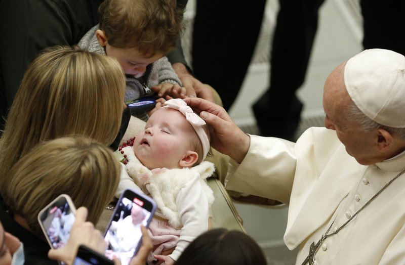 El papa Francisco saluda a un bebé dormido durante su audiencia general en la Basílica de San Pedro en el Vaticano el 24 de noviembre de 2021. (Foto CNS/Paul Haring)