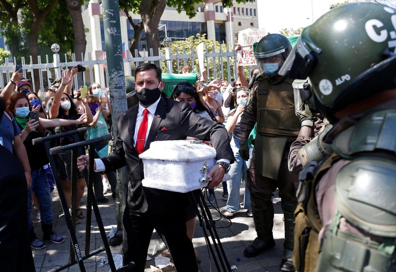 Un predicador con un ataúd vacío del tamaño de un niño es escoltado por agentes de policía cerca de activistas pro-vida y personas a favor de la despenalización del aborto en el exterior del congreso en Valparaíso, Chile, el 13 de enero de 2021. Legisladores en la cámara baja del Congreso de Chile el 30 de noviembre derrotaron un proyecto de ley que habría eliminado las sanciones penales por el aborto durante las primeras 14 semanas de embarazo. (Foto CNS/Rodrigo Garrido, Reuters)
