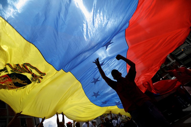 Partidarios del presidente Nicolás Maduro sostienen una bandera de Venezuela durante una manifestación en Caracas el 14 de agosto de 2017. Imagen referencial. (Foto CNS /Ueslei Marcelino, Reuters)