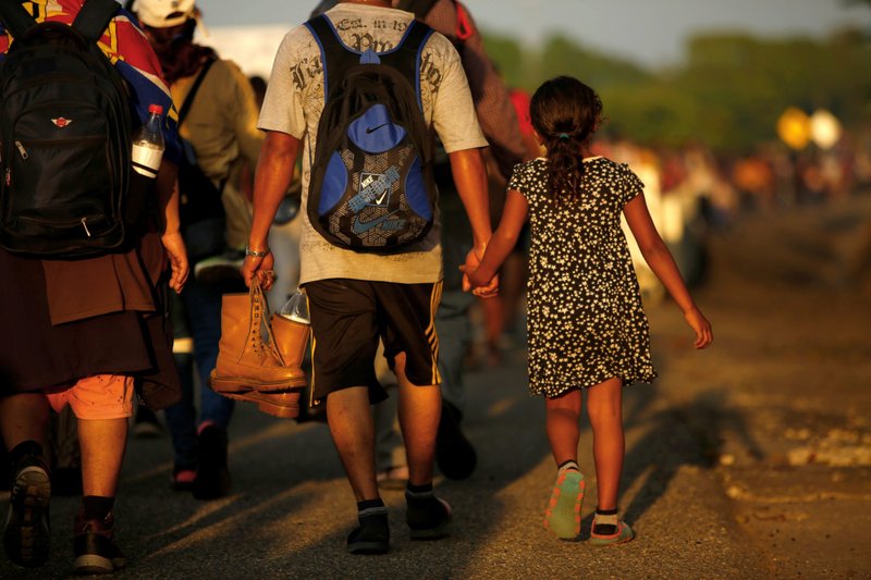 José Francisco de Honduras lleva a su hija de 8 años, Zuabelin, de la mano el 22 de noviembre de 2021, mientras participaban en una caravana cerca de Villa Mapastepec, México, en rumbo a la frontera con Estados Unidos. (Foto CNS/José Luis González, Reuters)