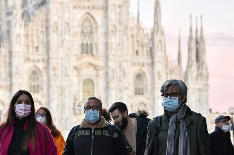 Un grupo de personas con cubrebocas camina cerca de la catedral de Milán en esta foto de archivo del 28 de noviembre de 2021. Un sacerdote, miembro de la Academia Pontificia para la Vida, escribió que usar una mascarilla de alta filtración durante misa es un "pequeño sacrificio" que se puede ofrecer a Dios. (Foto CNS/Flavio Lo Scalzo, Reuters)