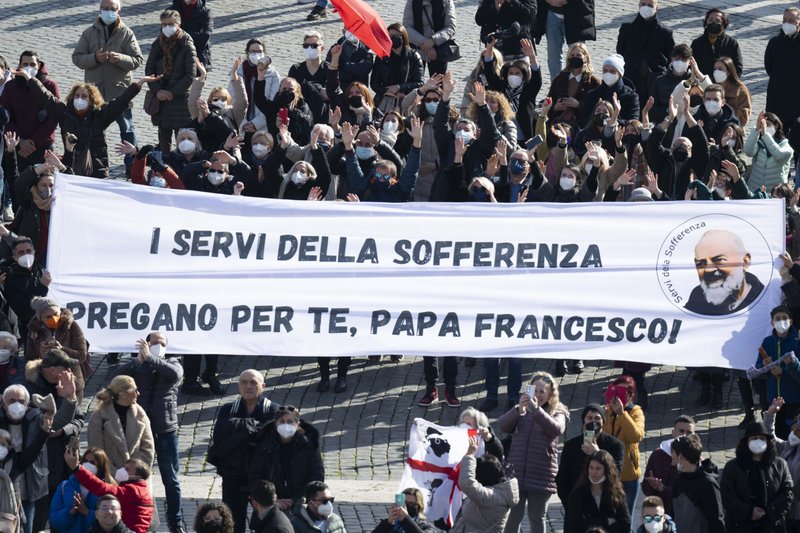 La gente sostiene una pancarta en italiano en la Plaza de San Pedro mientras el papa Francisco dirige el Ángelus desde la ventana de su estudio en el Vaticano el 23 de enero de 2022. La pancarta dice que el grupo italiano, Siervos del Sufrimiento, ora por el papa. (CNS photo/Vatican Media)