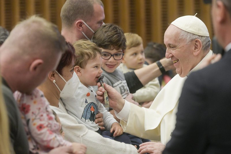 El papa Francisco juega con un niño mientras saluda a la gente durante su audiencia general en el Aula Pablo VI en el Vaticano el 16 de febrero de 2022. (Foto CNS/Vatican Media)