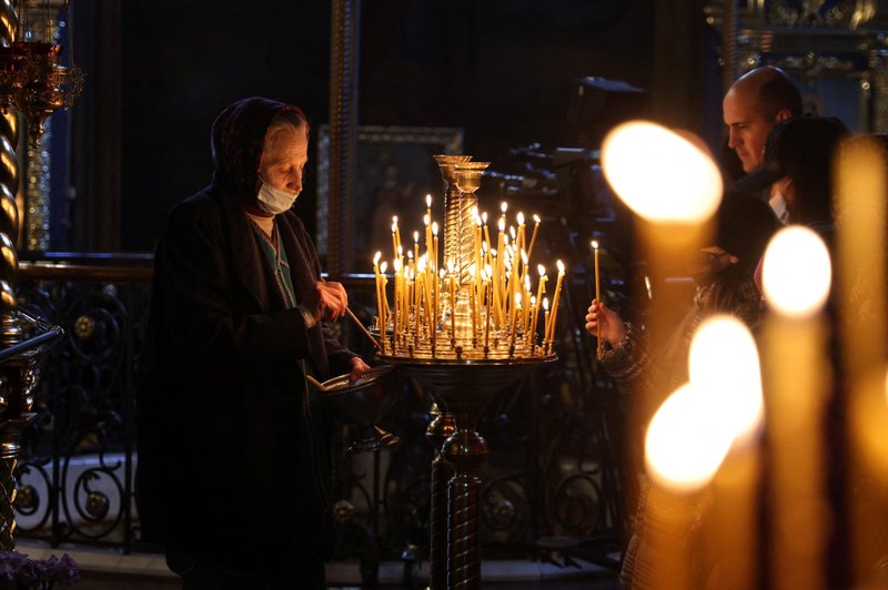 Fieles encienden velas en la Catedral de San Miguel de la Iglesia Ortodoxa de Ucrania en Kiev el 20 de febrero de 2022 mientras rezan por la paz. El papa Francisco expresó su "gran dolor" por la situación en Ucrania y pidió a los cristianos observar una jornada de oración y ayuno por la paz el Miércoles de Ceniza, 2 de marzo. (Foto CNS/Umit Bektas, Reuters)